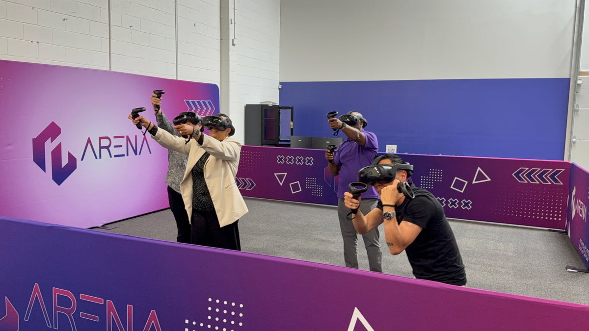 Four players in VR headsets aiming controllers in the Free Roam arena