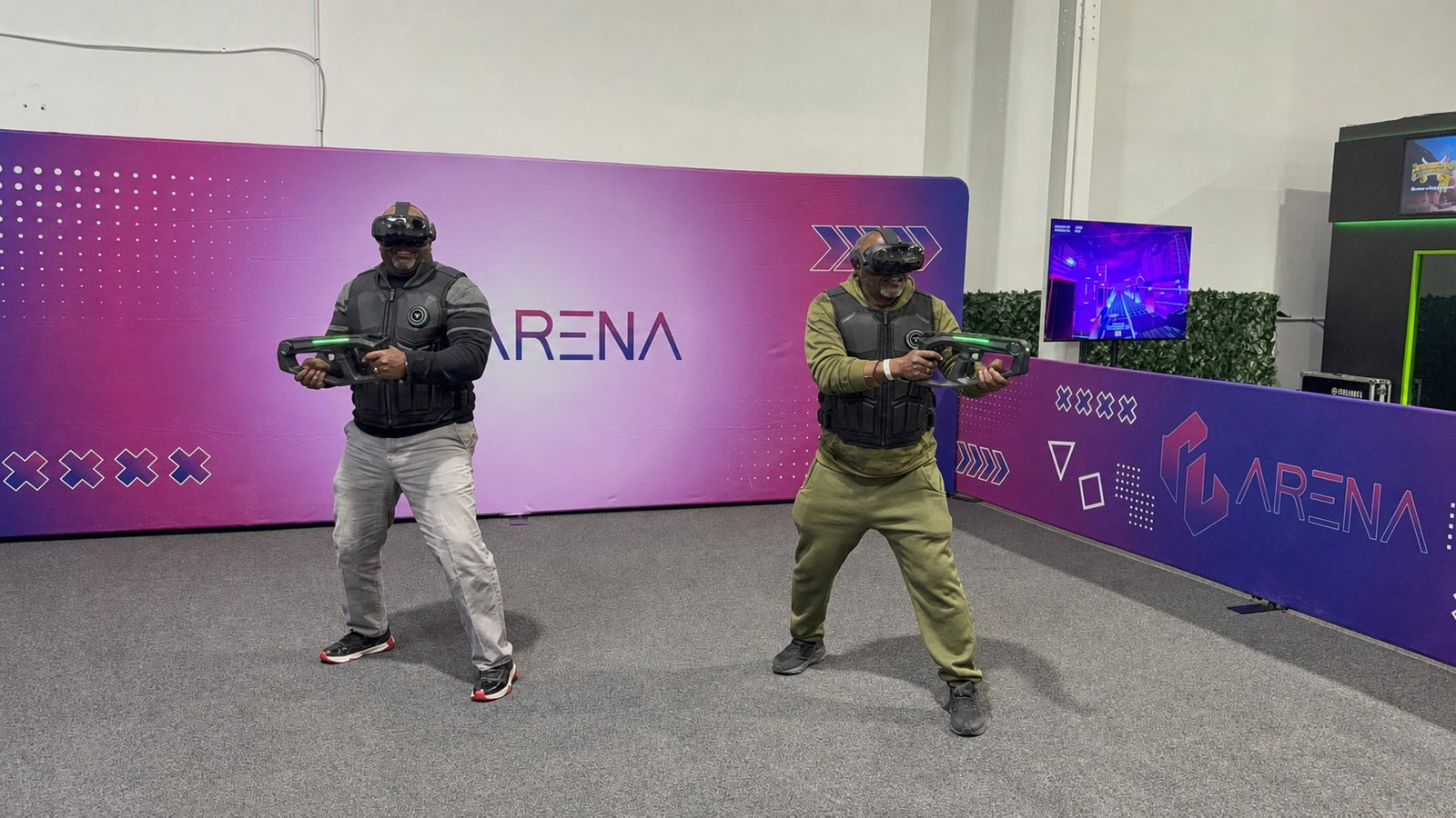 Two players geared up with haptic vests and blasters in the free-roam arena